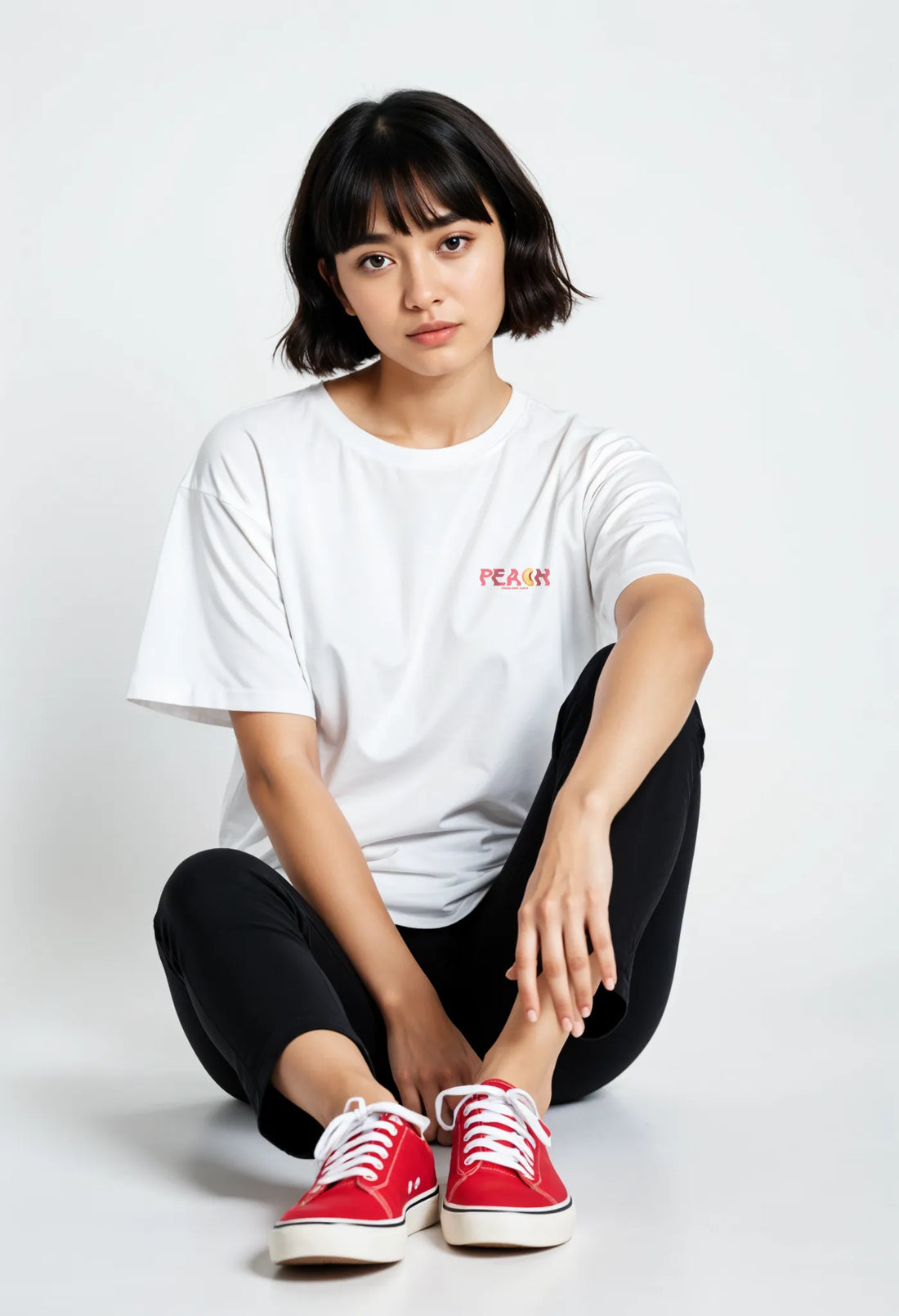 Empulse™ Peach Club t-shirt in white Sorona blend with small chest print, worn by female model sitting