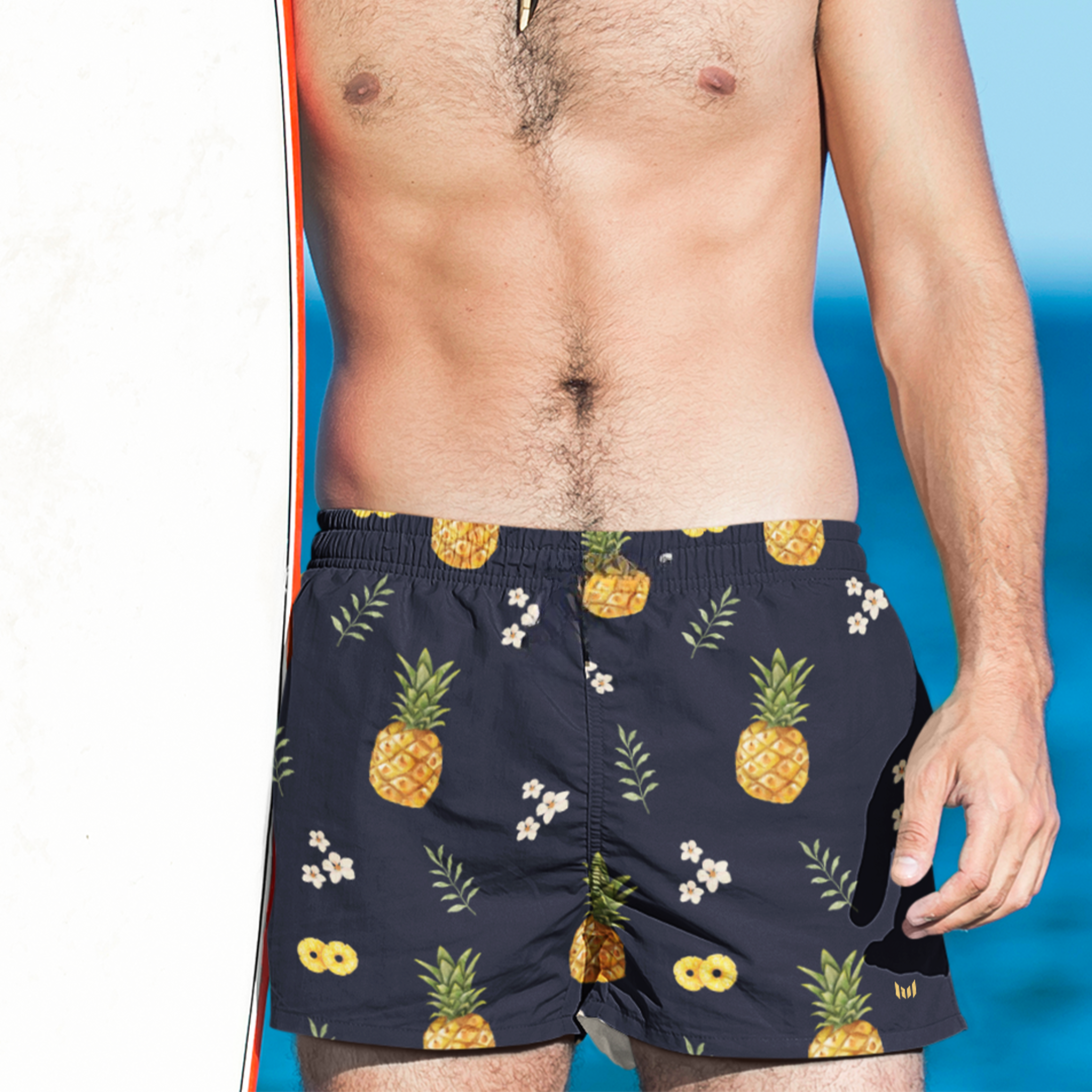 Empulse™ Pineapple Paradise swim shorts with tropical fruit print against blue studio background