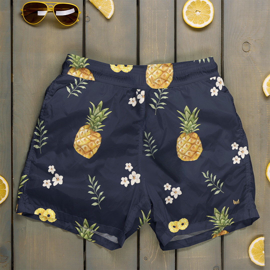 Pineapple Paradise shorts from Empulse™ hung on a door showcasing bold pineapple pattern