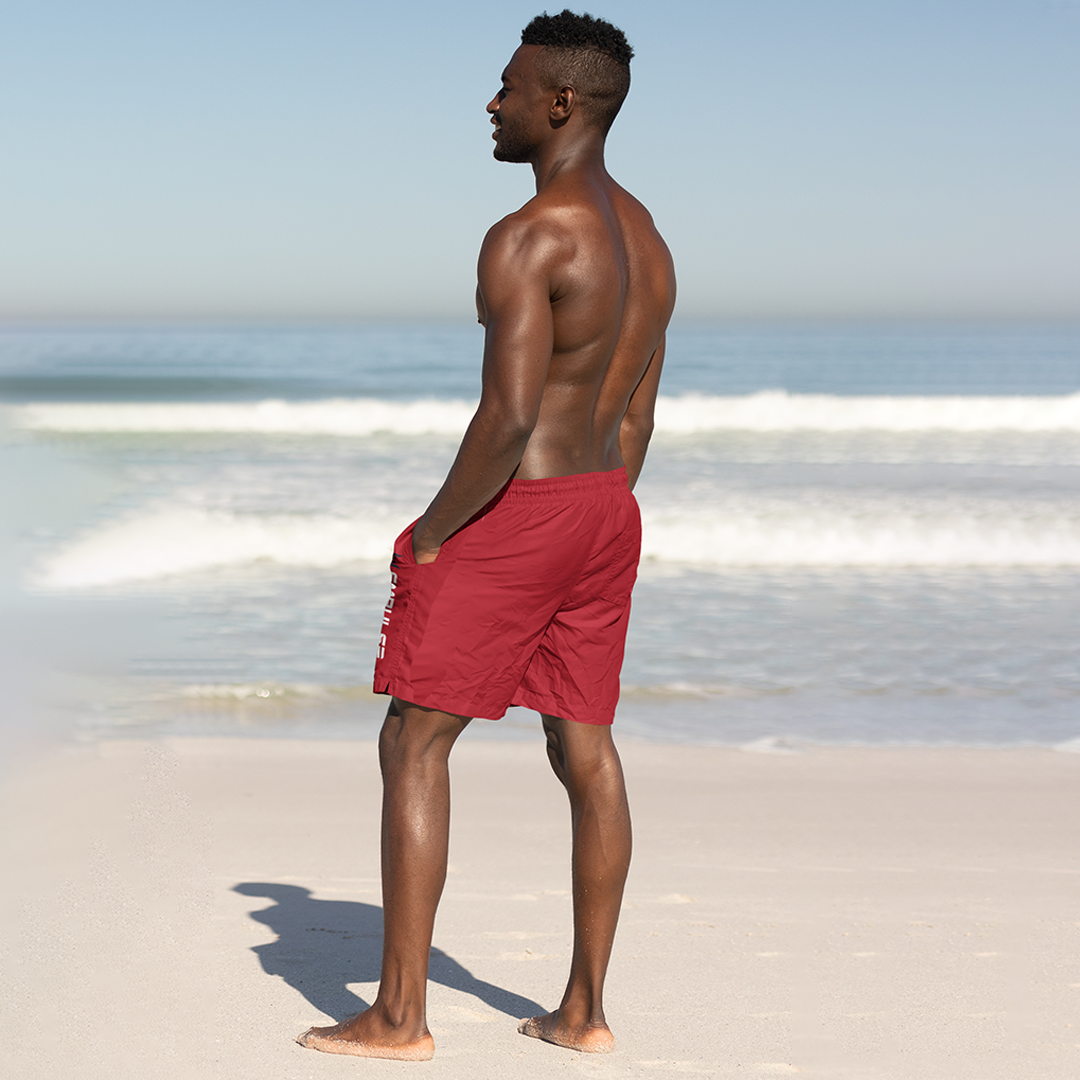 Rear view of Empulse™ Red swim shorts worn during walk along ocean shore

