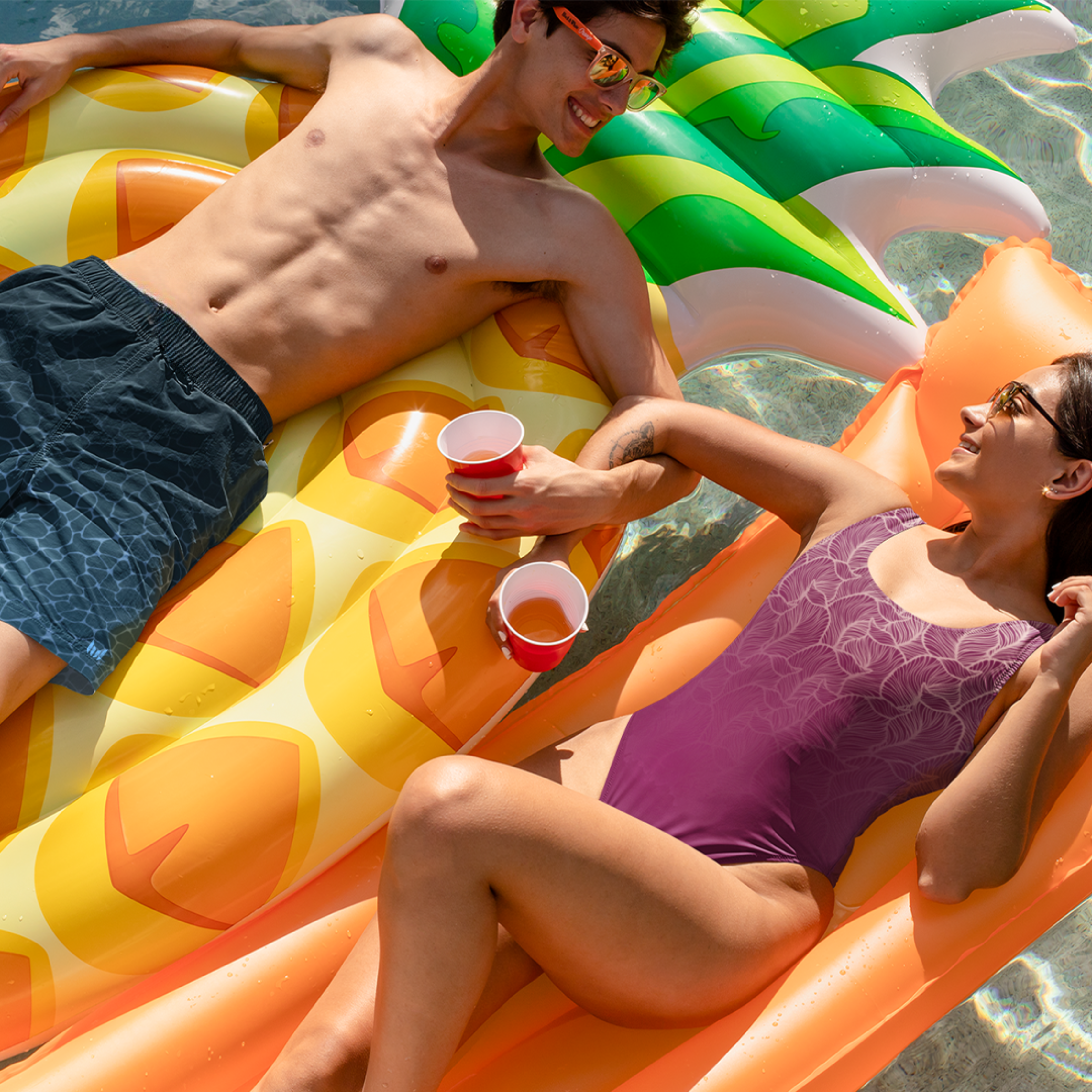Empulse™ Ripple Magic shorts worn in pool while lounging on colourful inflatable