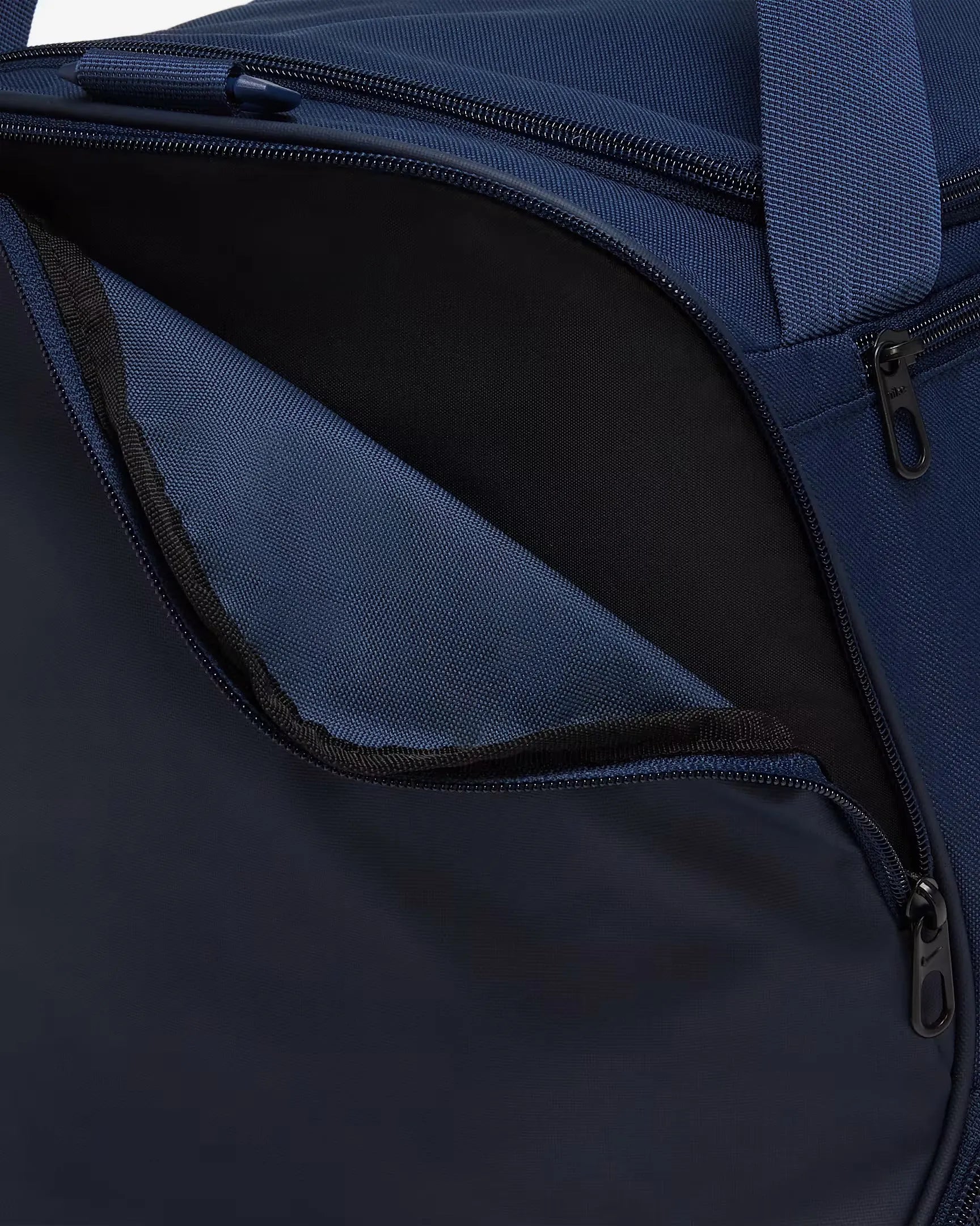 Close-up of front zipped compartment on Nike Brasilia duffel bag in navy blue