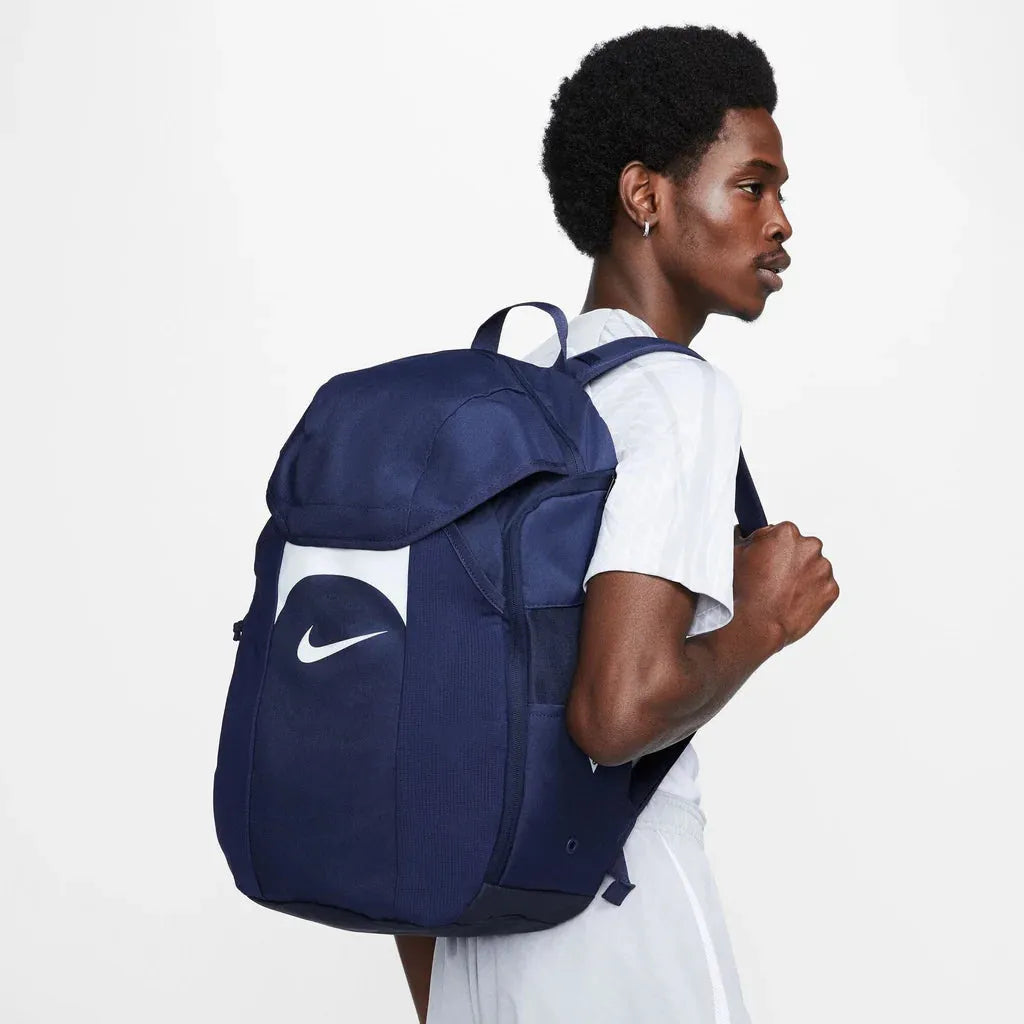 Male model in white tee wearing navy Nike Academy Team Backpack 30L