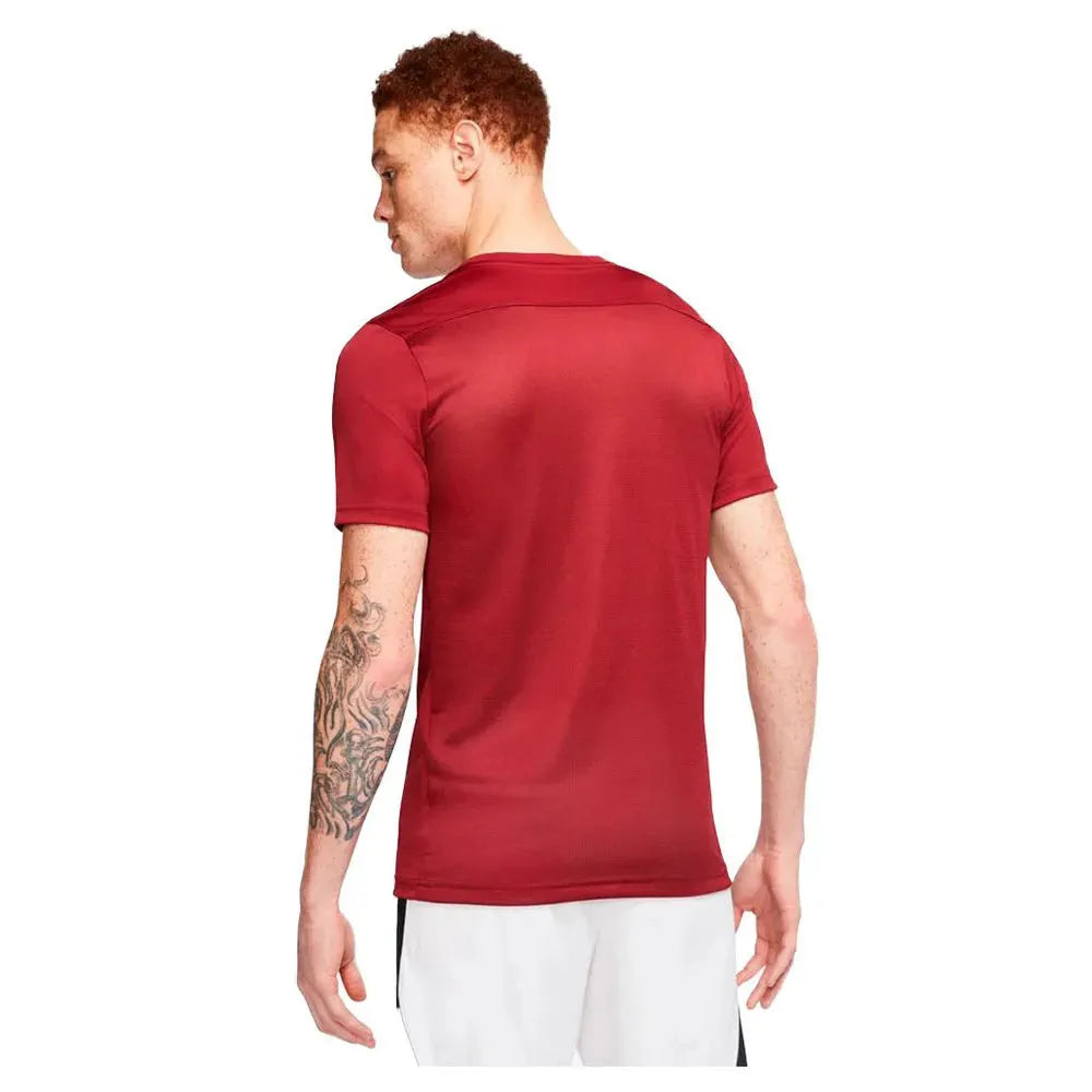 Model turned to show back view of red Nike Park 7 Jersey with white shorts
