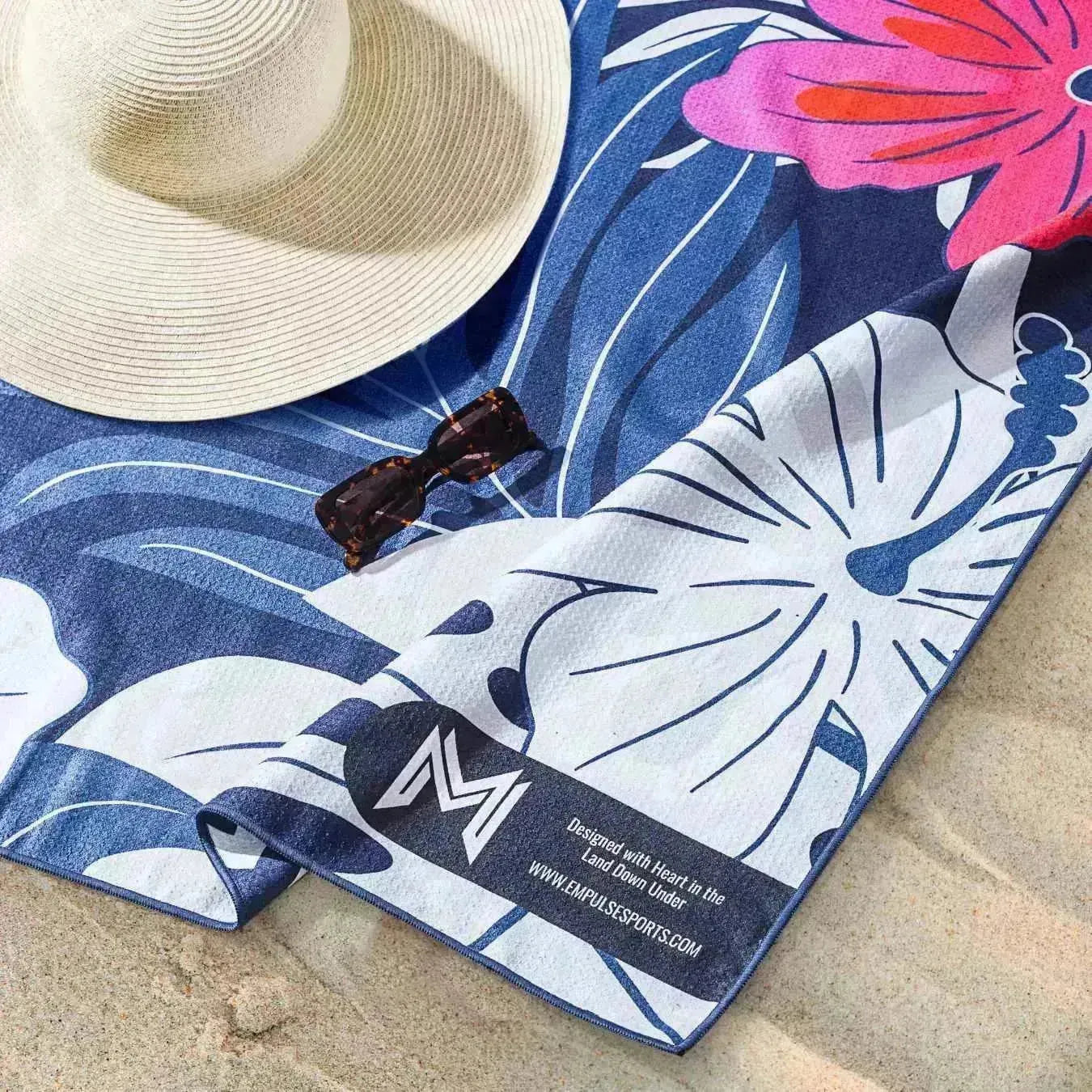 Model posing on beach at sunset holding Tropical Bloom towel
