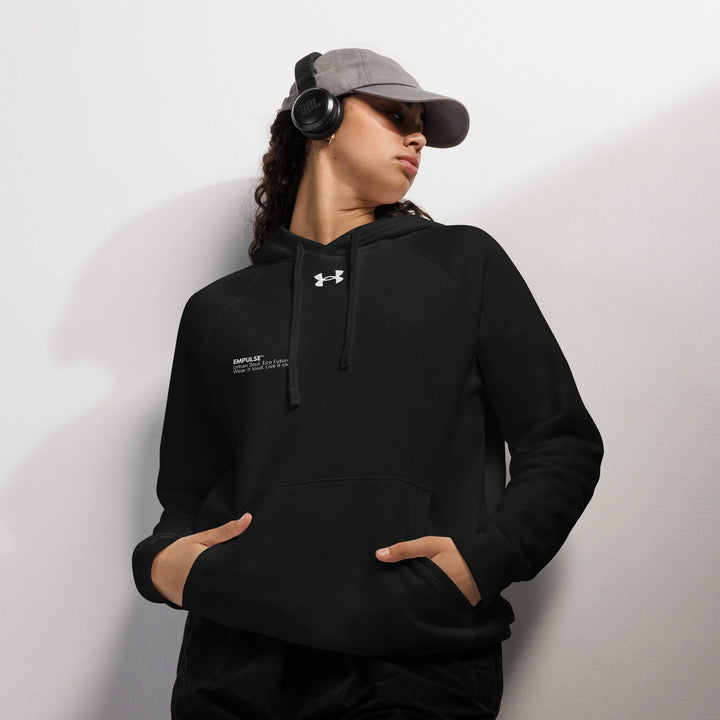 Black Under Armour hoodie worn by female model in relaxed stance